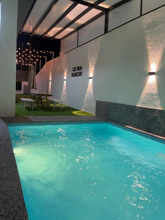 a pool with blue water in a building at Cik Yam Homestay Pool, Melaka l For Malay Only in Melaka