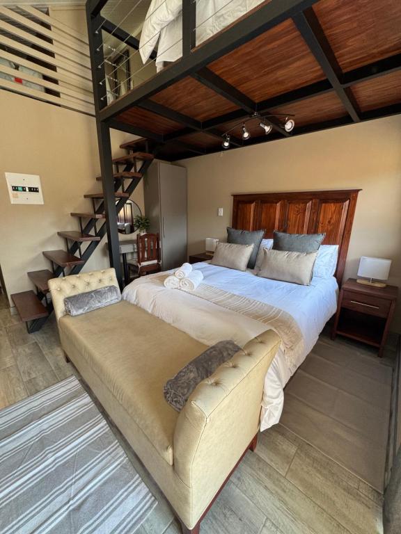 a bedroom with a large bed and a staircase at Leanie's Place in Clarens
