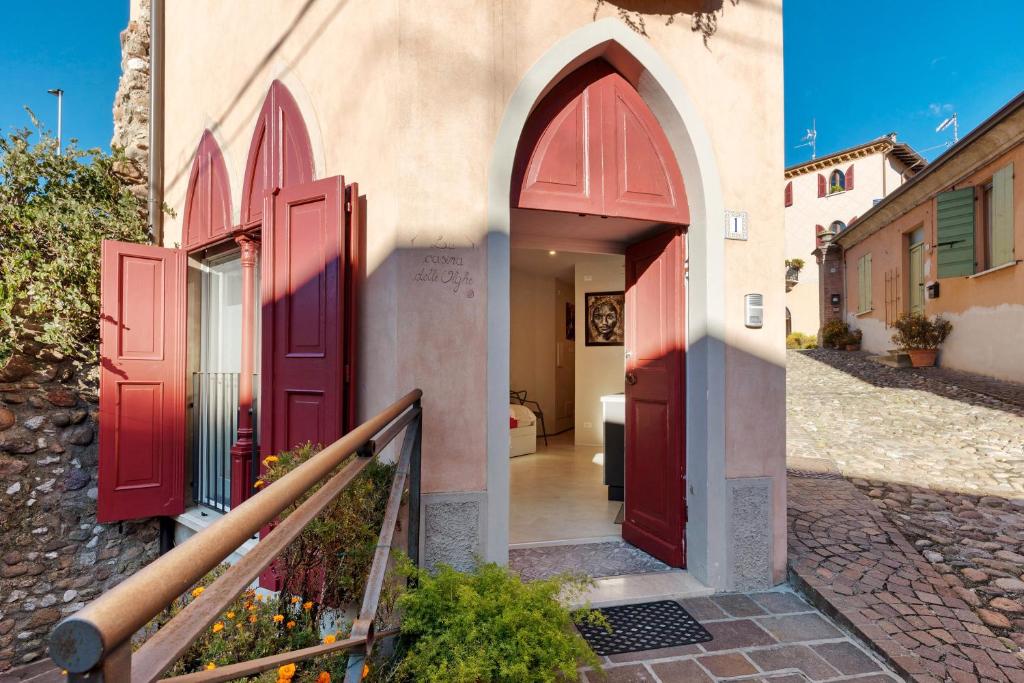 two pictures of a building with red doors at La Casina Delle Olghe 3 in Cavriana