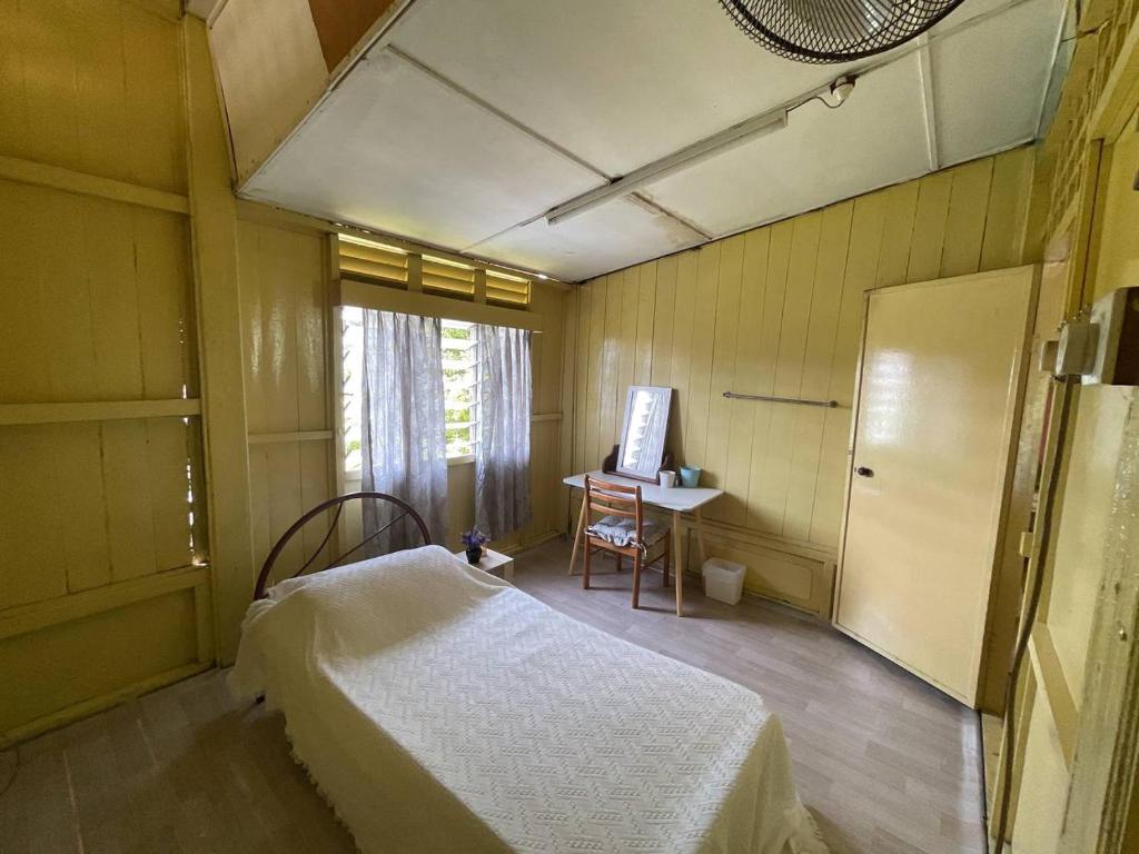 une chambre avec un lit, un bureau et une fenêtre dans l'établissement Rooma Rustic Homestay, à Kuala Kangsar
