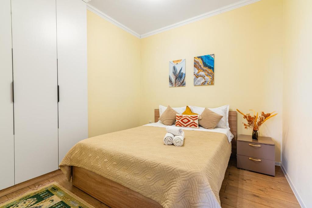 ein Schlafzimmer mit einem Bett mit zwei Handtüchern darauf in der Unterkunft Просторная квартира с балконом в ЖК Атлант in Almaty