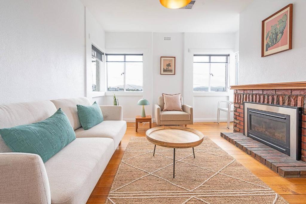 a living room with a couch and a fireplace at 1950 Serenity - Classic Hobart Escape near CBD in West Hobart