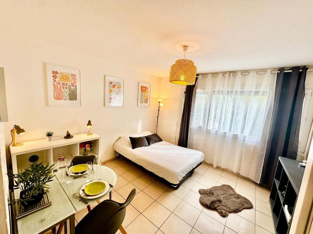 Un dormitorio con una cama y una mesa en una habitación. en Flowers Studio, en Saint-Julien-en-Genevois