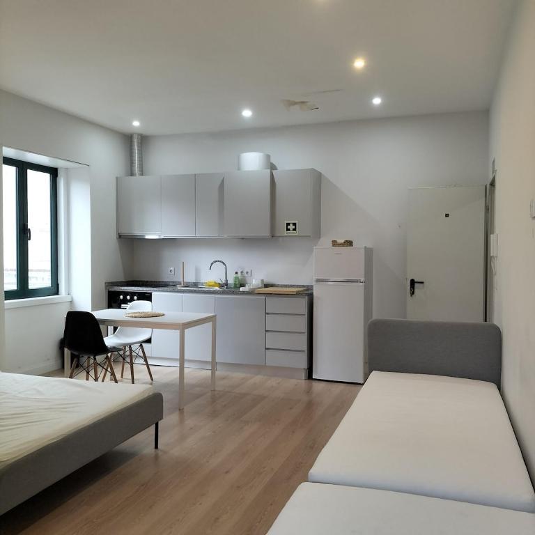 a white kitchen with a table and a couch at Douro Vila 10 - Best View in Town in Bandeira