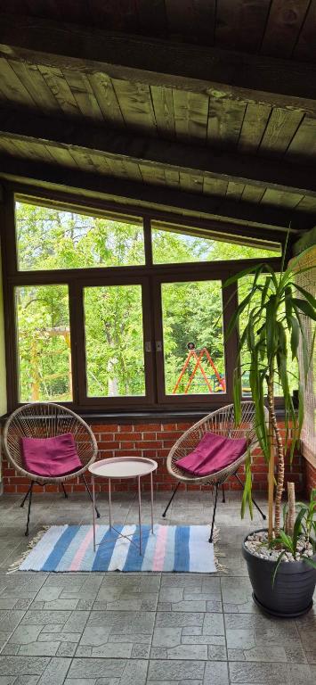 three chairs and a table in a room with windows at Dream weekend house in Visoko