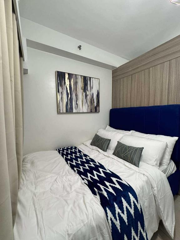 a bedroom with a large bed with a blue headboard at Blisshaven SHORE 2 B03-14100 in Sampong