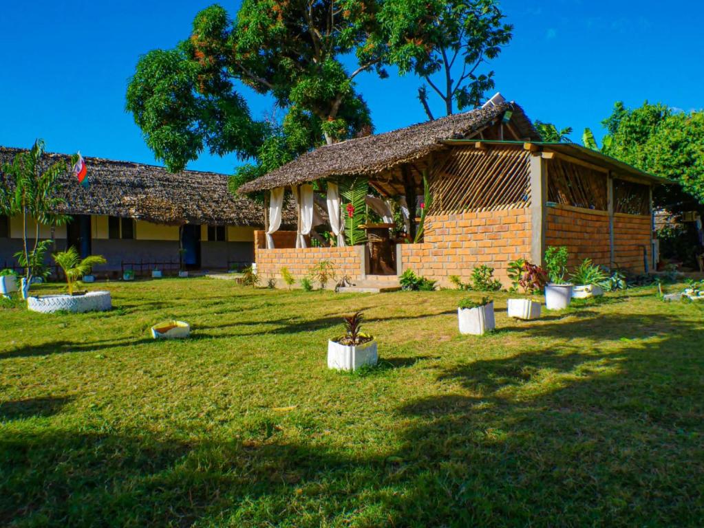 a house with a grass yard in front of it at Le Relais de Djangoa in Djangoa