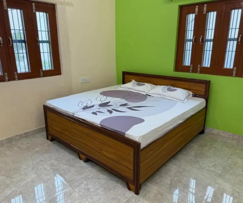 Cama en habitación con paredes verdes en Stay Enjoy, en Jāmb