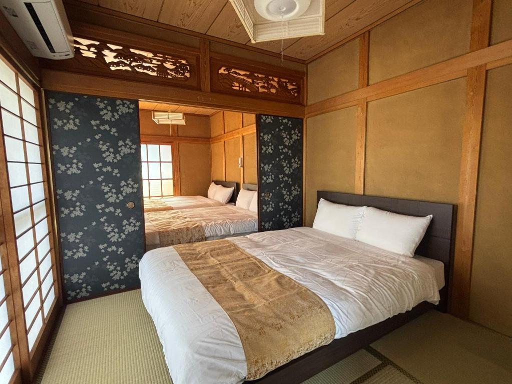 a bedroom with two beds in a room at P-Stay宮島中西町 in Hatsukaichi