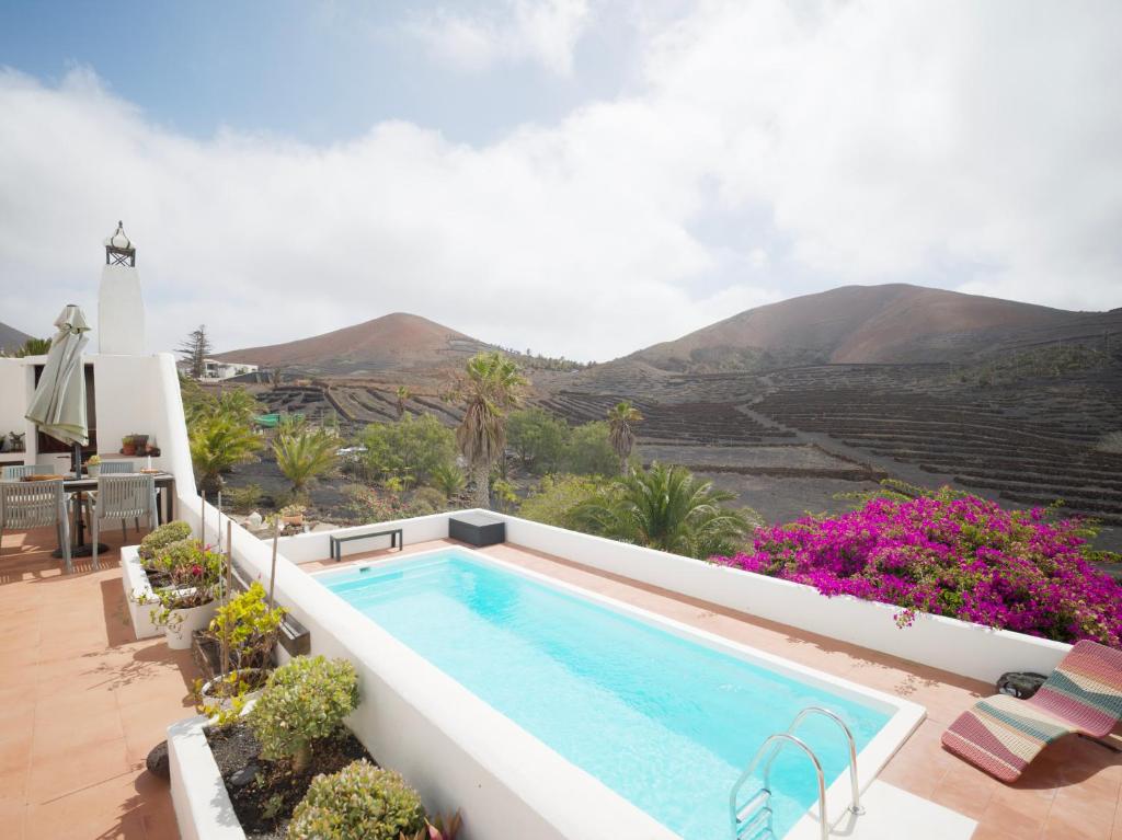 una piscina en un patio con montañas al fondo en Casa MaVi - Vineyard with heated pool, en La Vegueta
