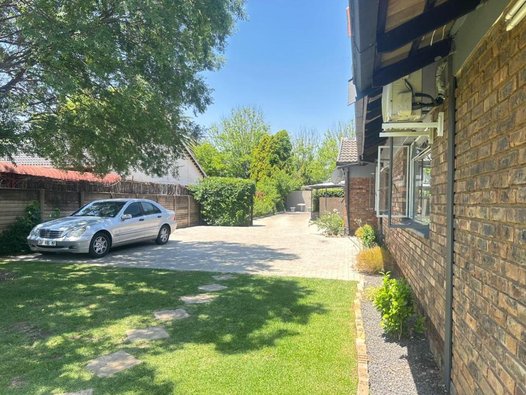 a car parked in a driveway next to a house at Creekside Guest House Middelburg in Middelburg