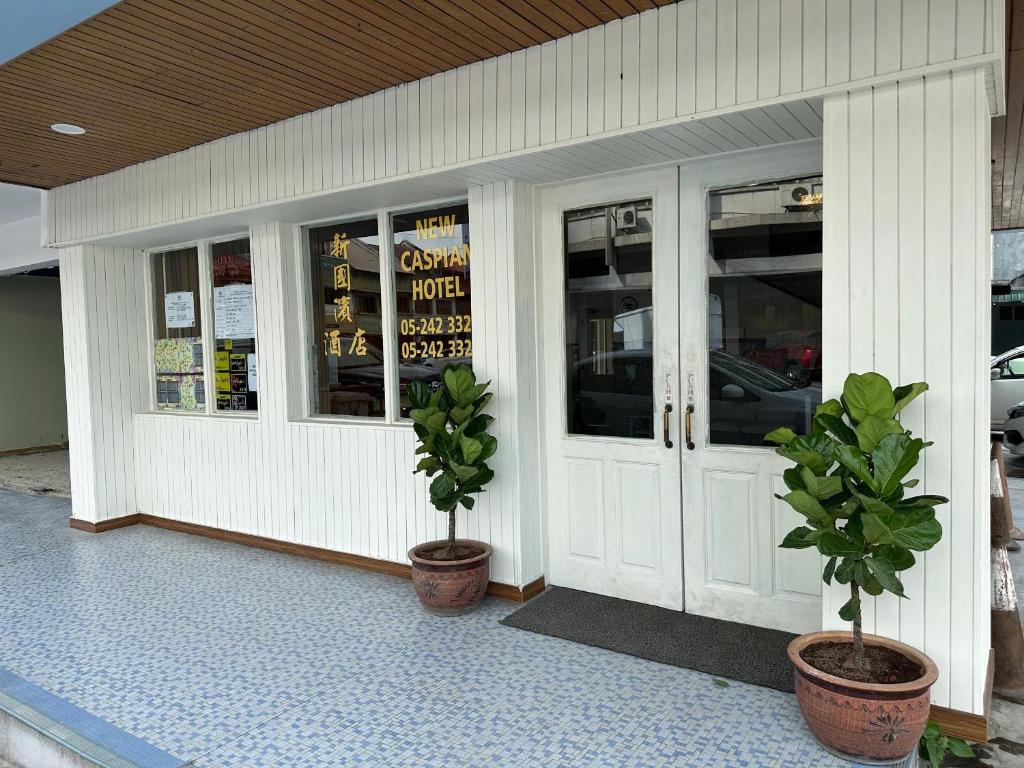 a store front with two potted plants in front of it at New Caspian Hotel in Ipoh