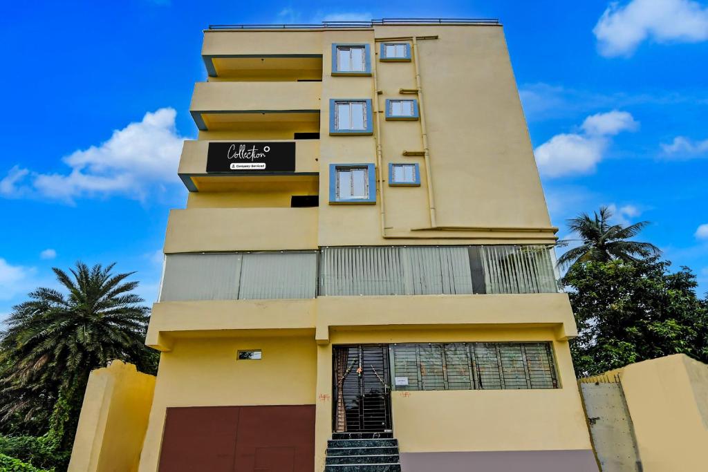 a tall yellow building with a sign on it at Super Collection O Mourigram Near Andul Road in Sānkrāil