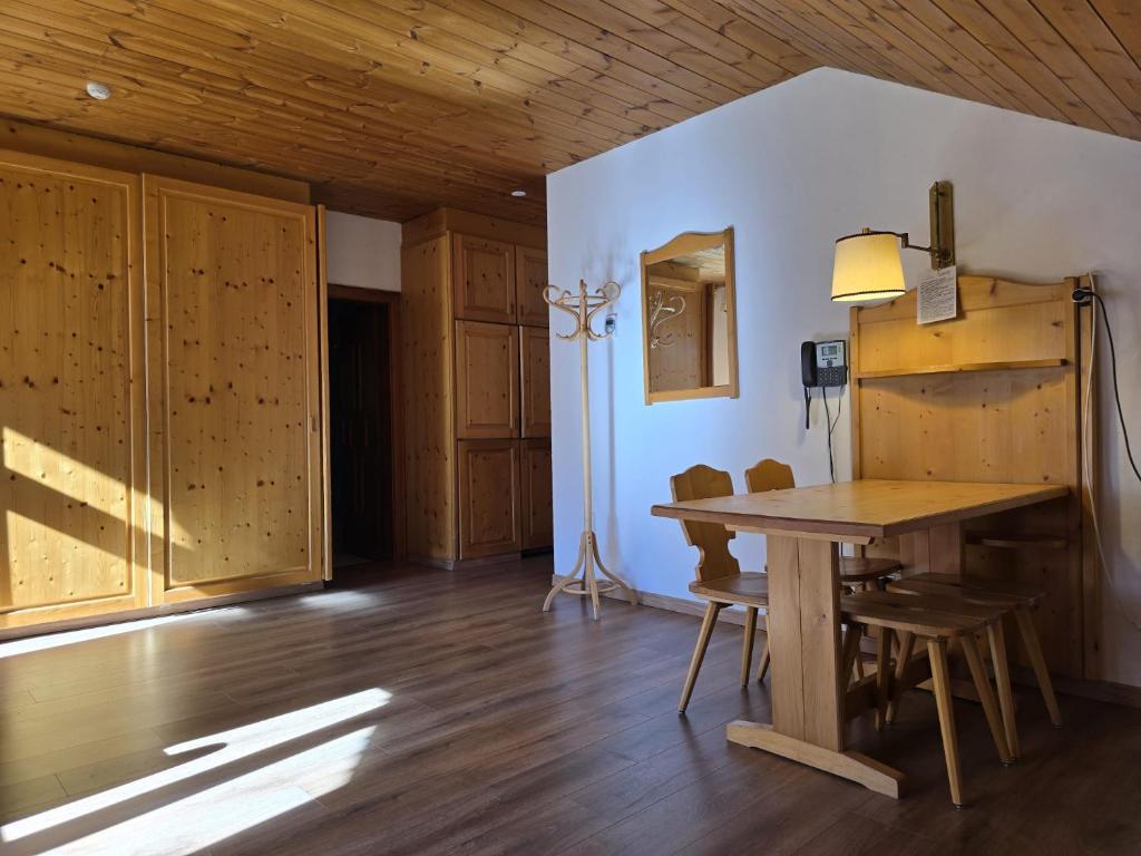 a dining room with a wooden table and chairs at Aparthotel Carbonin in Dobbiaco