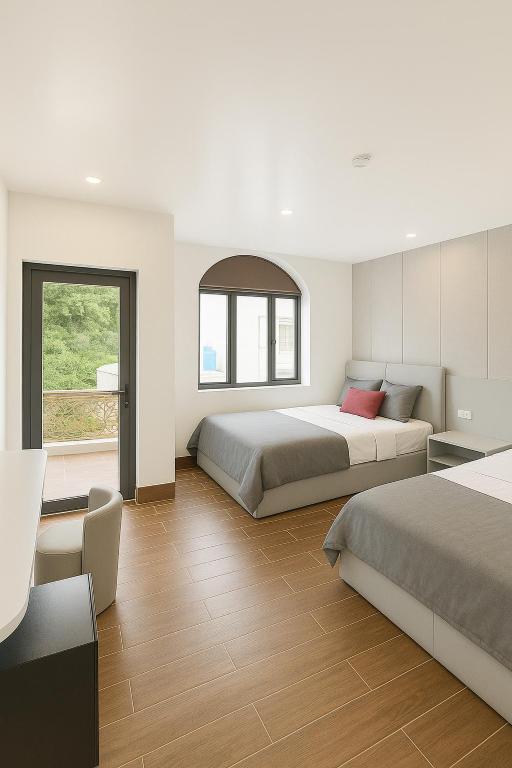 a bedroom with two beds and a table at Hoàng Huy Hotel in Cat Ba