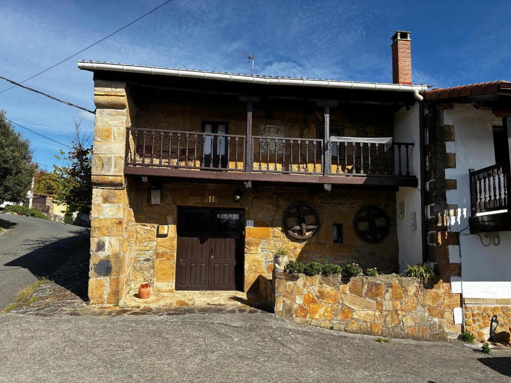 ein Steinhaus mit Balkon darüber in der Unterkunft Arbide, caserio tradicional vasco en Carranza in Karrantza