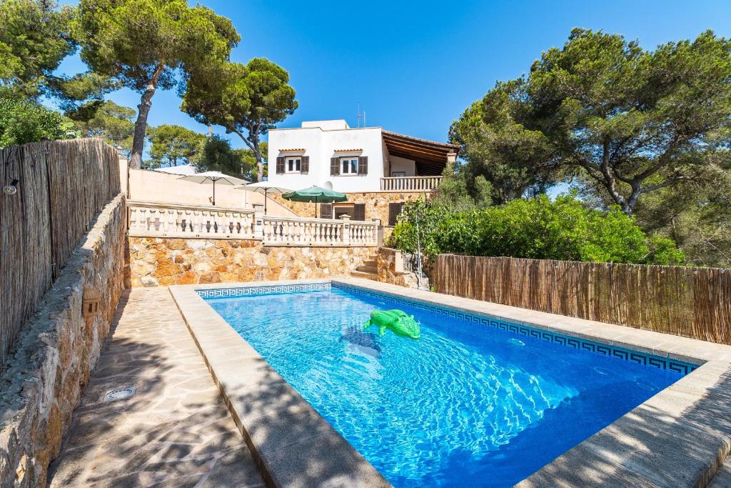 a swimming pool in front of a house at Villa Escaletas in Cala Santanyi