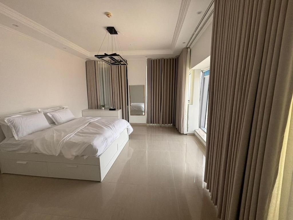 a bedroom with a white bed and a large window at Elegant apartment overlooking the sea in Jeddah