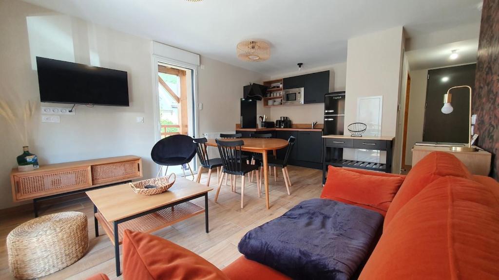 a living room with a couch and a table and a kitchen at Beau logement 5 pers, proche de toutes commodités in Loudenvielle