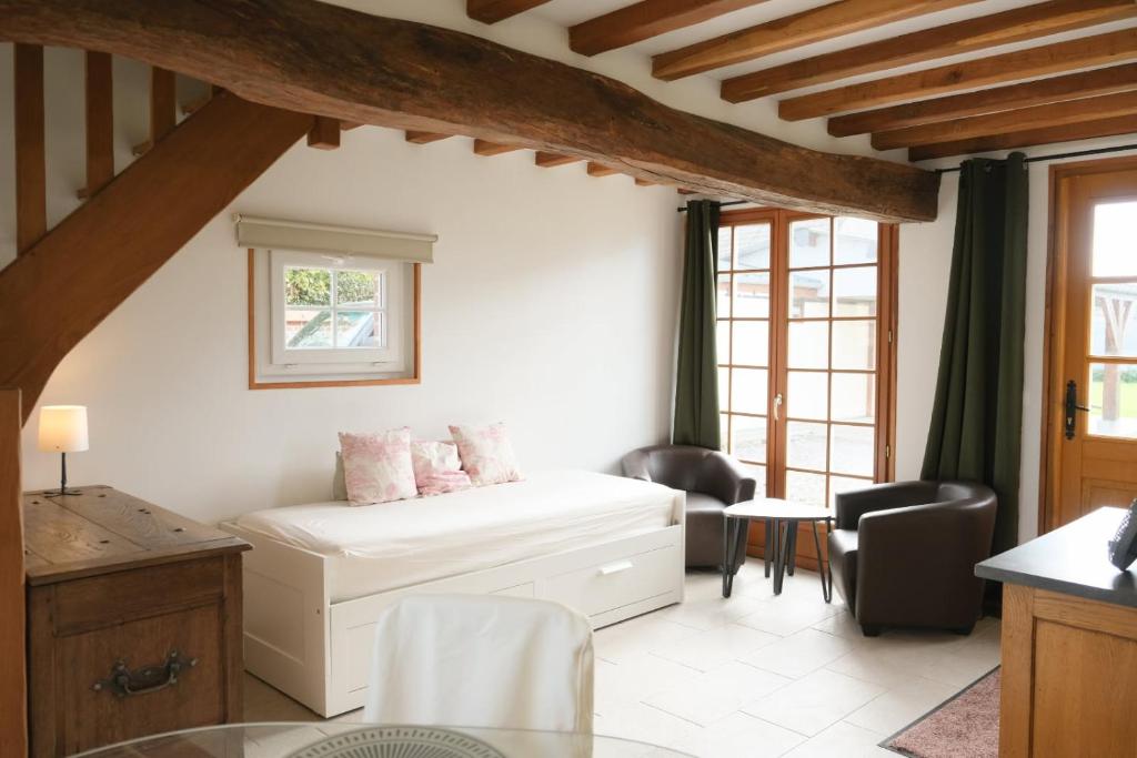 a living room with a bed and a table at La Sellerie et Le Relais des Hortensias in Graincourt