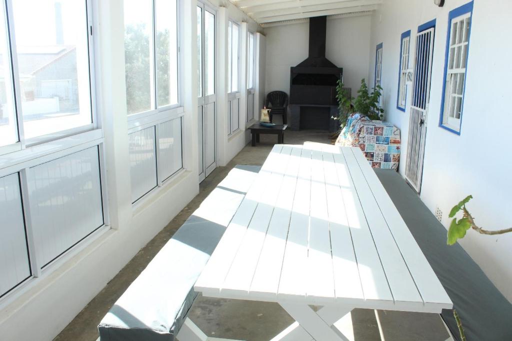 a white bench in a room with windows at Pik & Pikkie Self catering apartments in Lambertʼs Bay