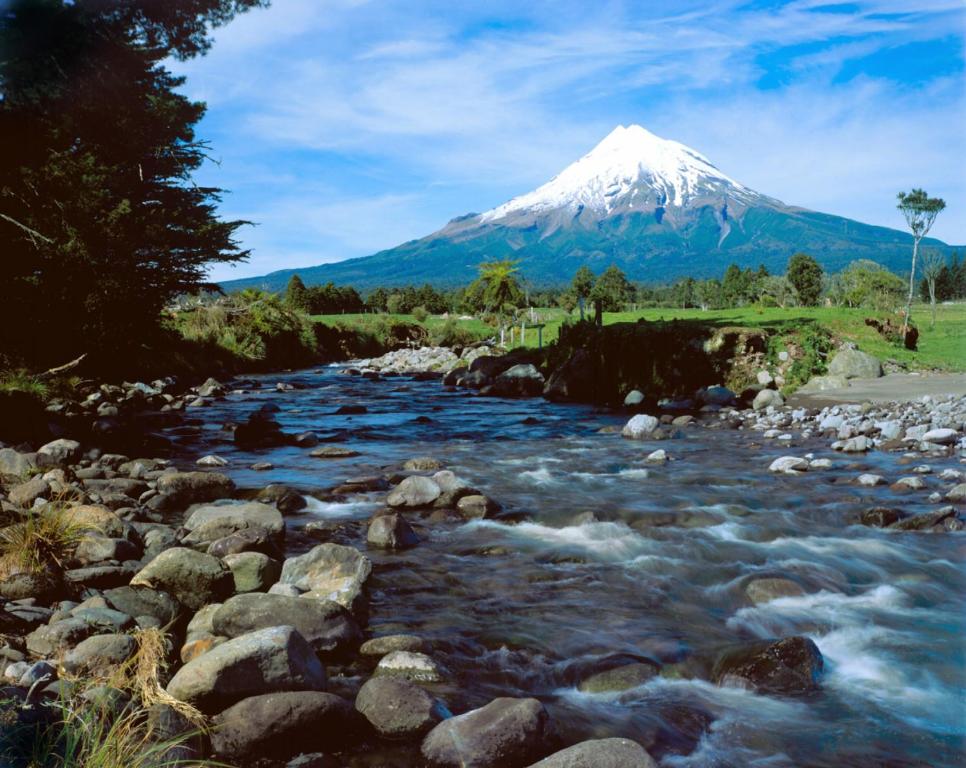 einen Berg und einen Fluss mit einem Berg im Hintergrund in der Unterkunft Egmont Eco Leisure Park & Backpackers in New Plymouth