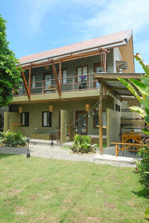 a large house with a porch and a patio at Central Loft 2-3 mins away from Surf Spots in General Luna
