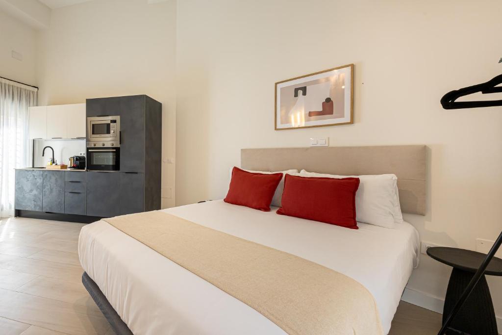 une chambre avec un grand lit blanc avec des oreillers rouges dans l'établissement Dobo Málaga Perchel, à Malaga