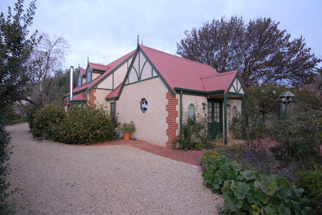 una pequeña casa de ladrillo con techo rojo en The Dove Cote en Tanunda