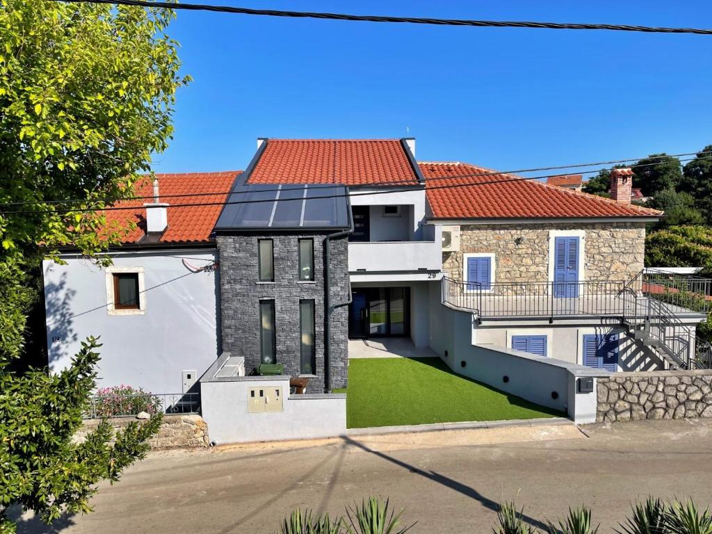 an image of a house with solar panels on the roof at Apartments Bonum in Šilo