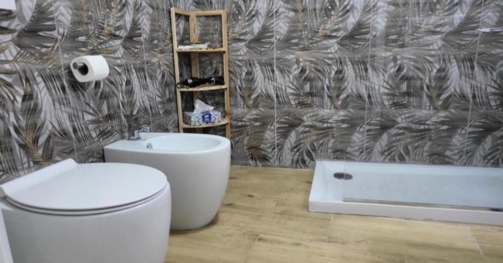 a bathroom with a toilet and a sink and a tub at Idromasage room in Catania