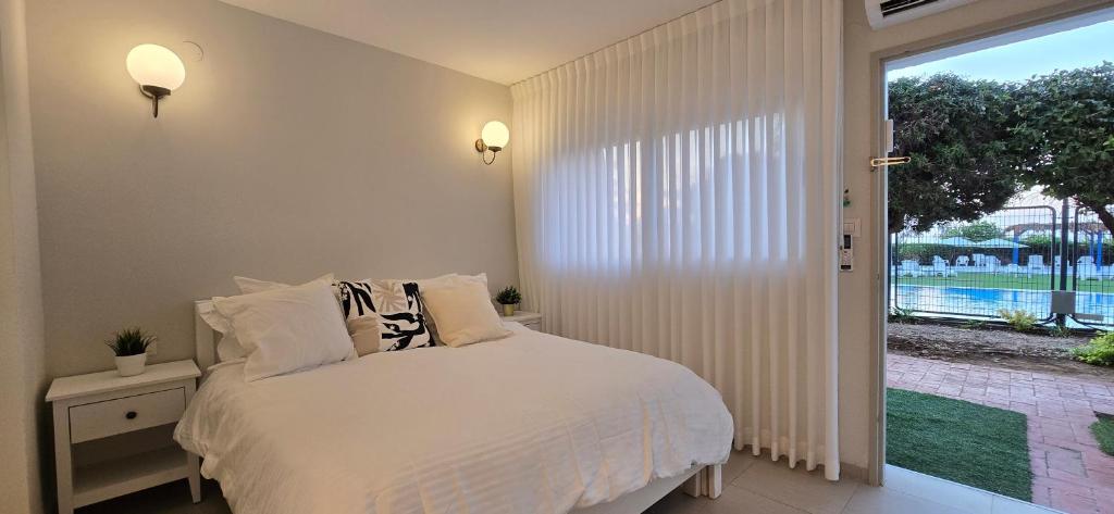 a bedroom with a bed and a large window at GoldSea - Boutique Seafront Studio in Nahariyya