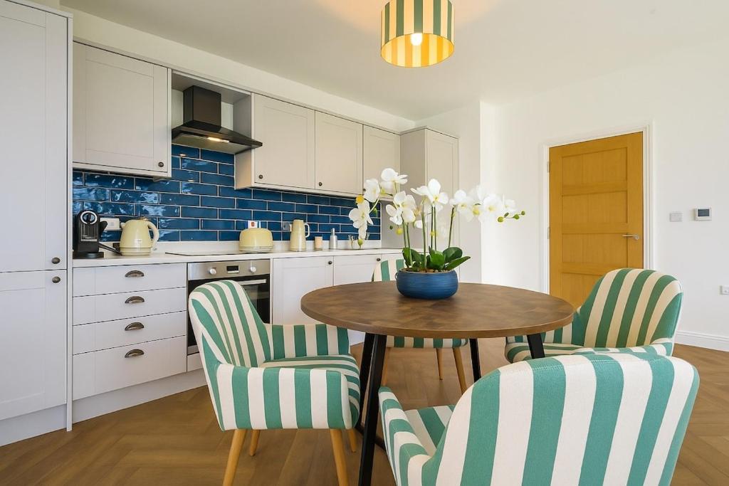 a kitchen with a table and chairs with a vase of flowers at Highfields House Spinny Hill Northampton in Spinney Hill