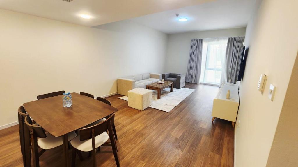 una sala de estar con una mesa y un sofá en Havana Holiday Homes in Al Garhoud, en Dubái