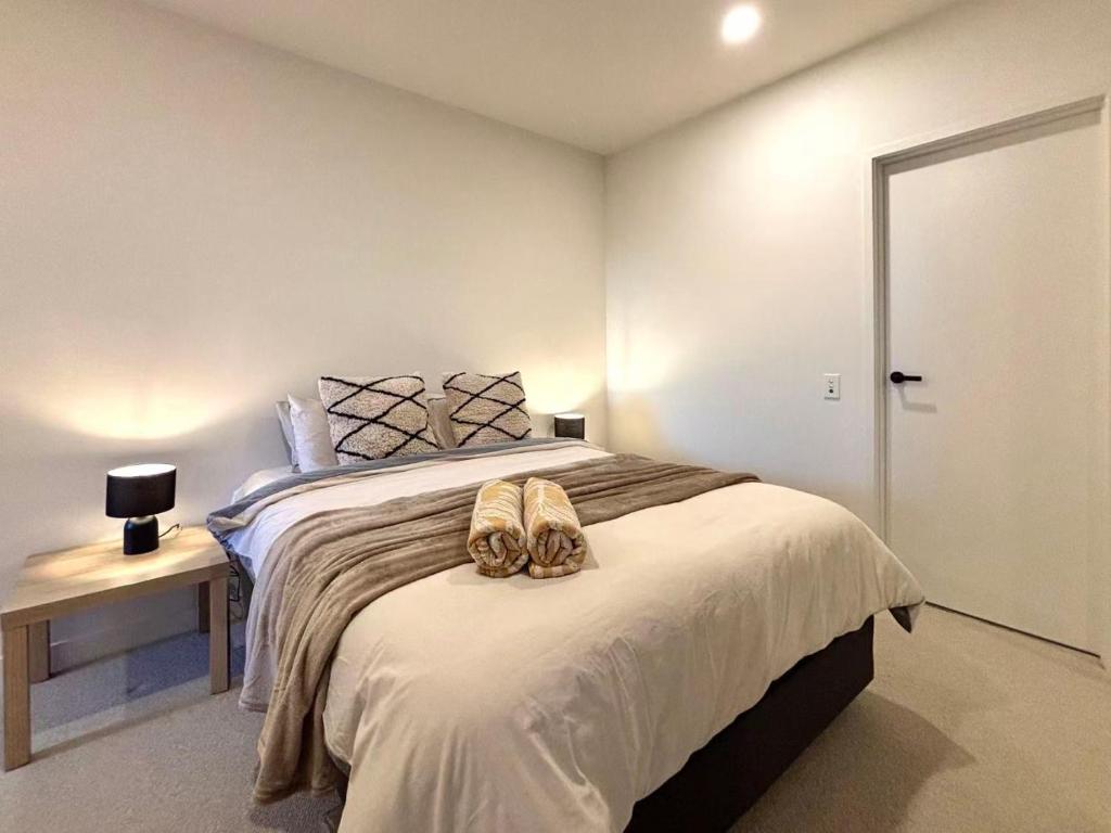 a bedroom with a bed with two shoes on it at Mcity Clayton Urban 2BR with Stunning View in Clayton North