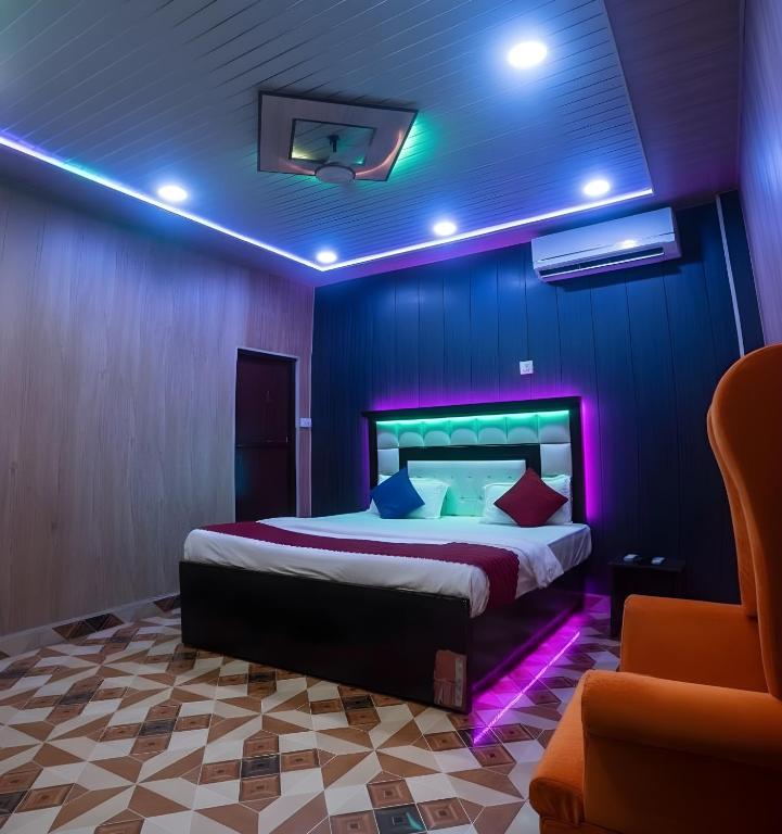a bedroom with a bed with purple lights on it at TRIP MY BUDDY Hotels in Varanasi