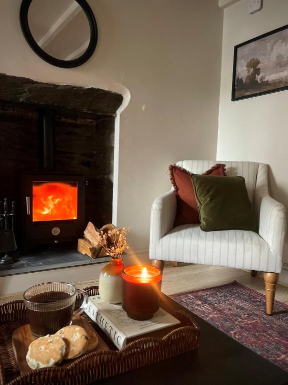 een woonkamer met een bank en een open haard bij Poets Cottage Eglwys Fach in Eglwys-fach