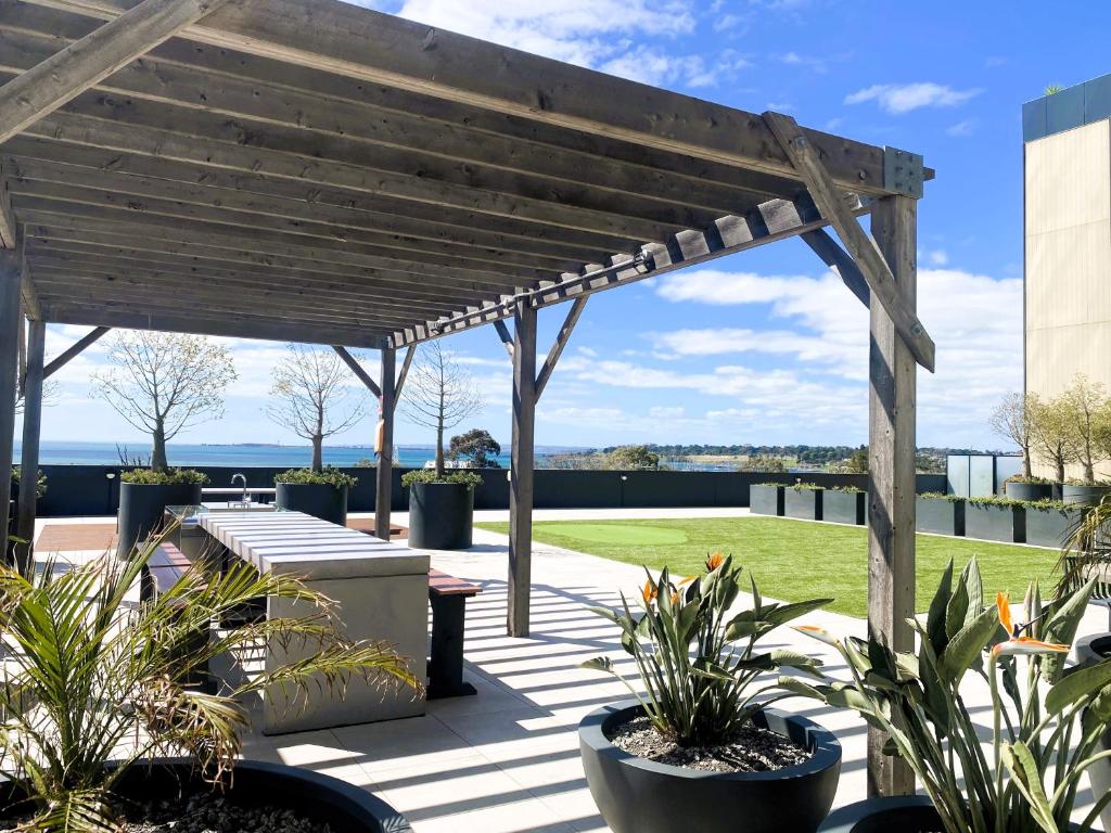 a wooden pergola over a patio with plants at MERCER APARMENTS 2 Bedroom Apartment with Bay Views on the Geelong Waterfront - 609 in Geelong
