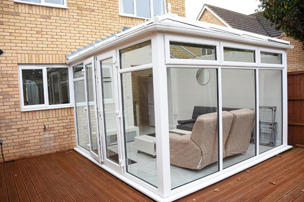 een witte serre met daarin een stoel bij Peterborough Haven: 3BD Family Home Retreat in Peterborough