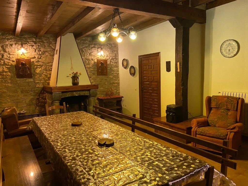 a living room with a table and a fireplace at Casa Rural Masión de Egüés in Elcano