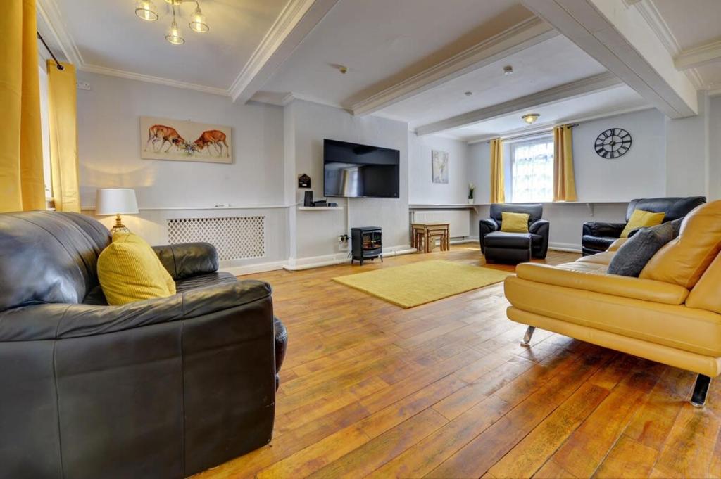 a living room with two couches and a yellow couch at 5 bedrooms, sleeps up to 16, secure parking space & comfort in Skegby