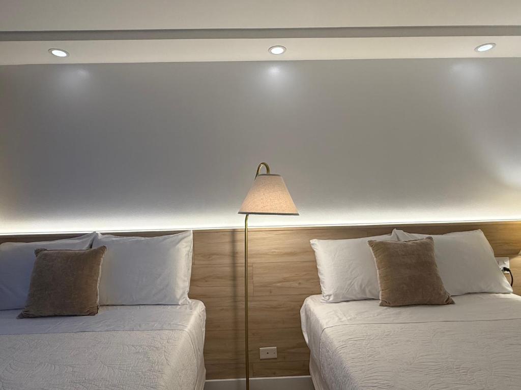 ホノルルにあるNewly renovated luxury, modern style Waikiki Sunset Hotel Ocean view Freeparkingのベッド2台(ランプ付)が備わるベッドルーム1室を利用します。