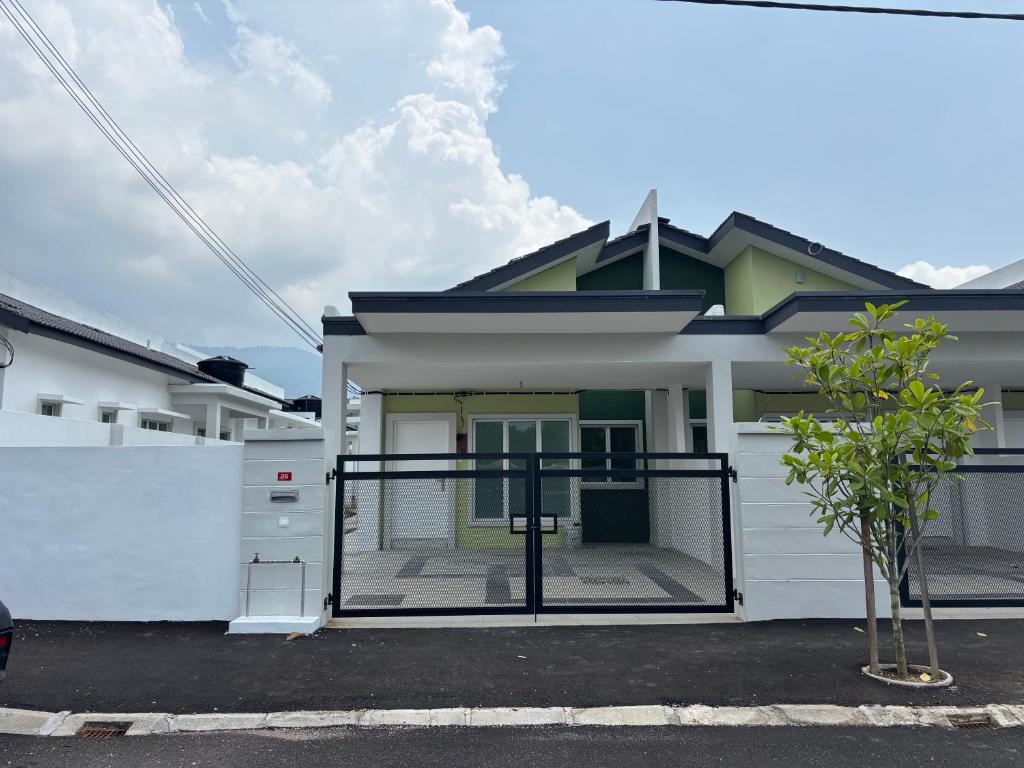 a house with a gate in front of it at Amoura Stay in Chemor