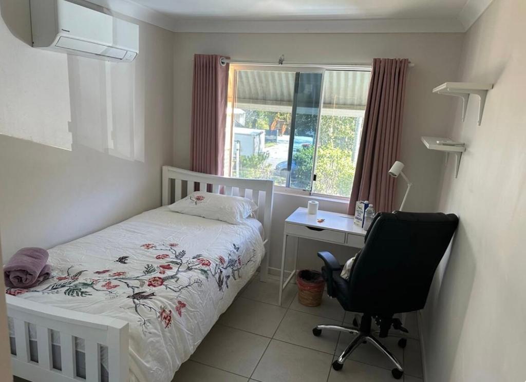 een slaapkamer met een bed, een bureau en een stoel bij UQ single bedroom with pool Q2 in Brisbane