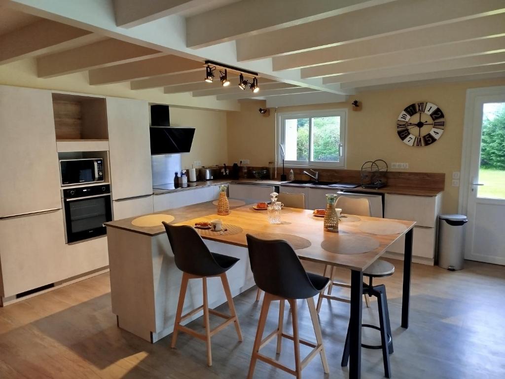 een keuken met een grote houten tafel en stoelen bij École des fans in Narrosse