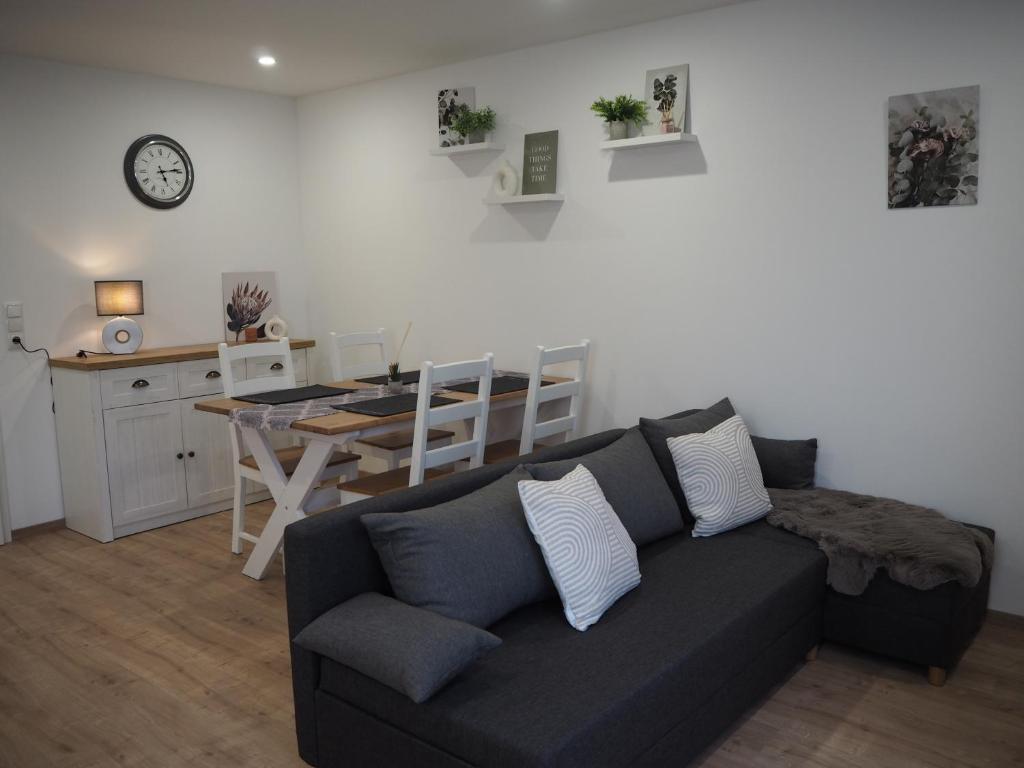 a living room with a black couch and a table at Ferienwohnung am Mühlenweg in Petershagen