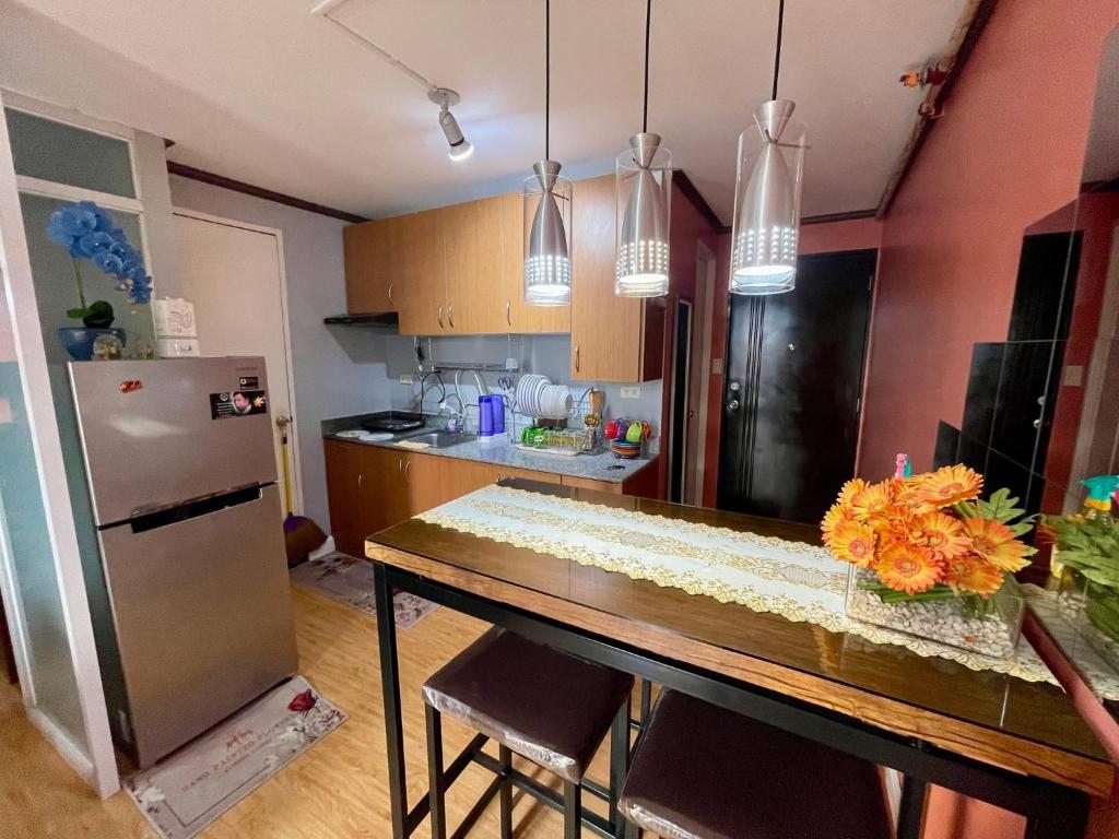 a kitchen with a table and a refrigerator at Arezzo Place Condominium in Davao City