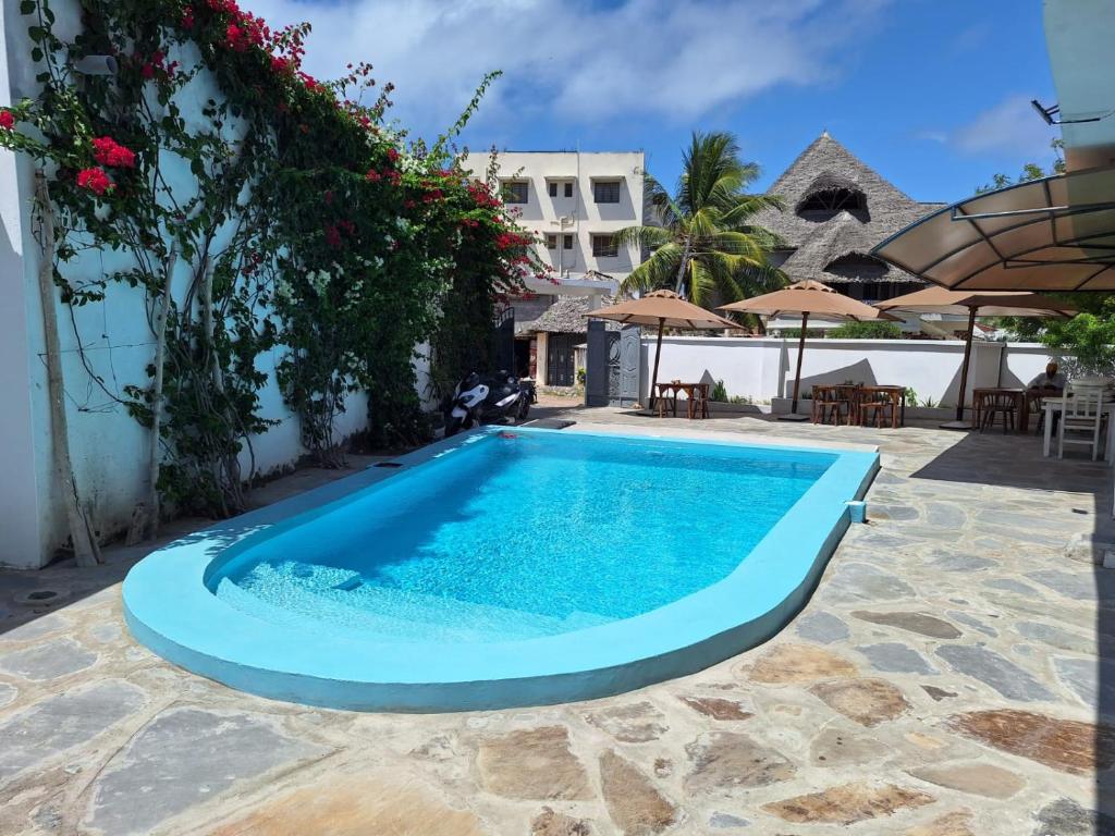 a swimming pool in the middle of a resort at Nyumba Maua B&B in Watamu