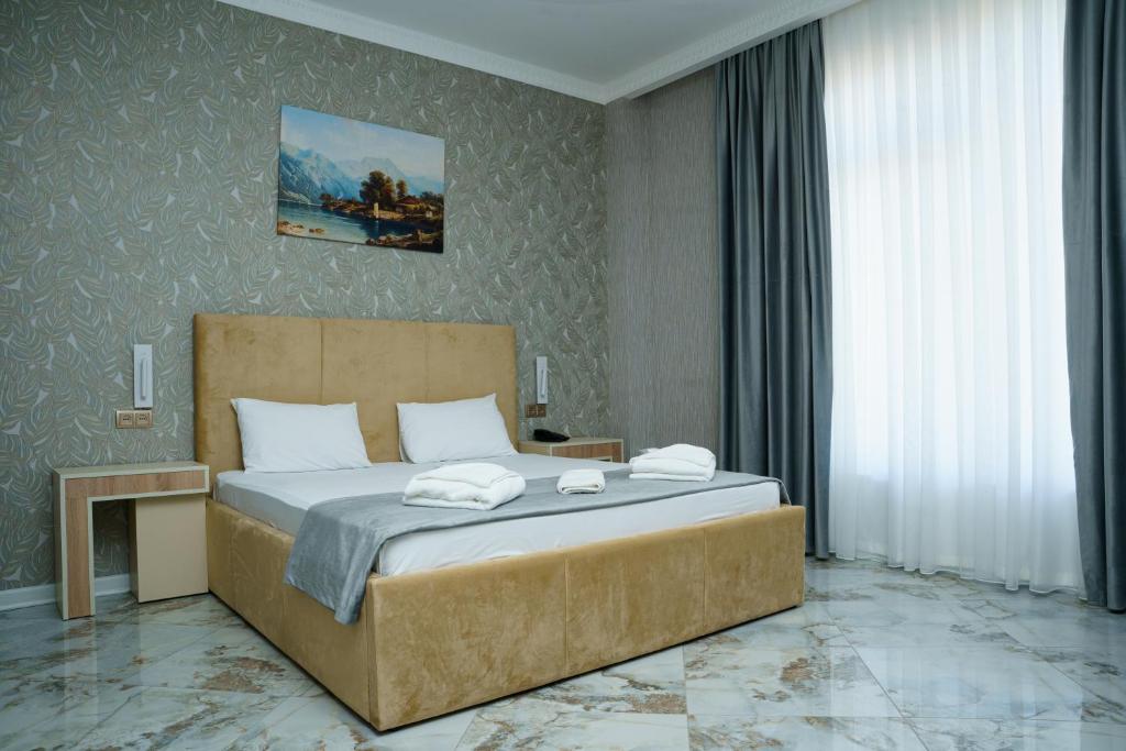 een slaapkamer met een groot bed met handdoeken erop bij Kolizey Hotel Spa Ganja in Ganja