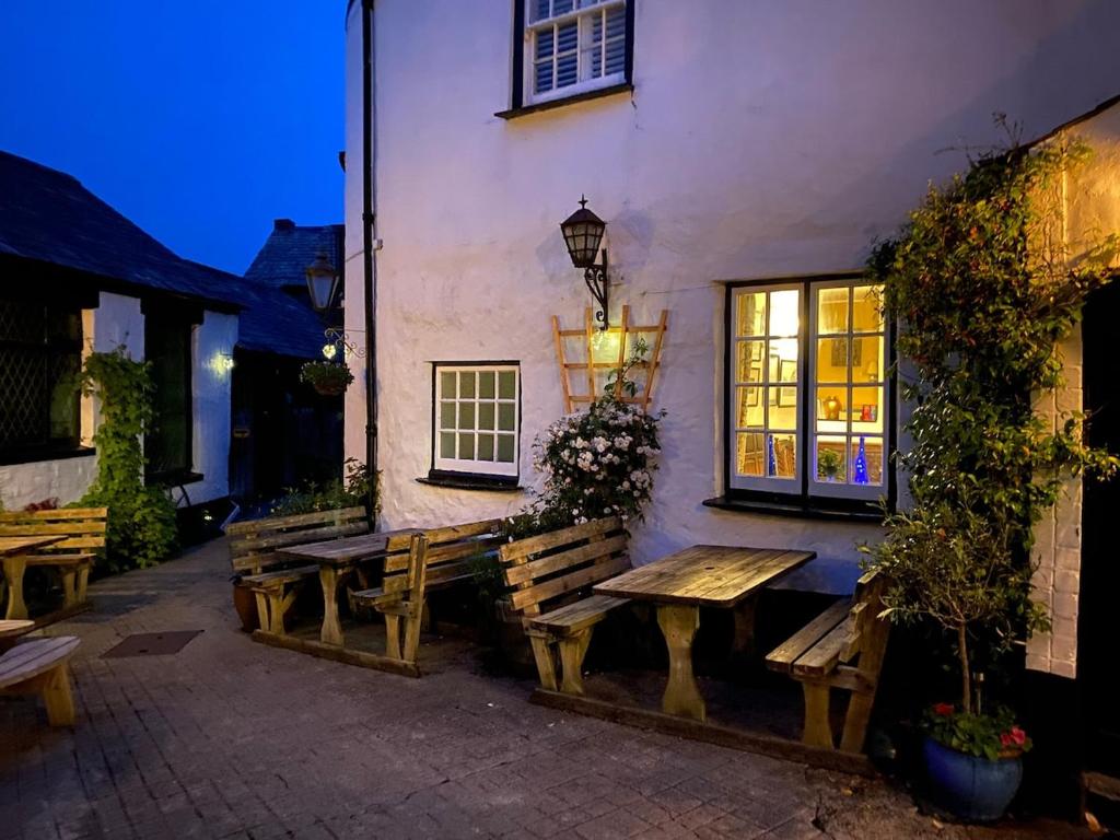 a picnic table and bench outside of a building at Small cottage in Stratton, Bude in Stratton